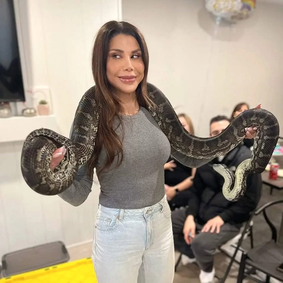 An adult guest holding a large snake