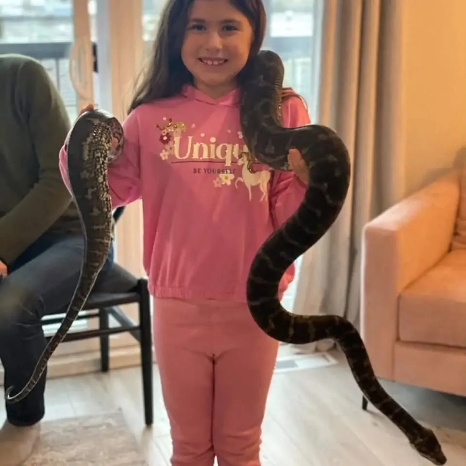 Child holding a large snake